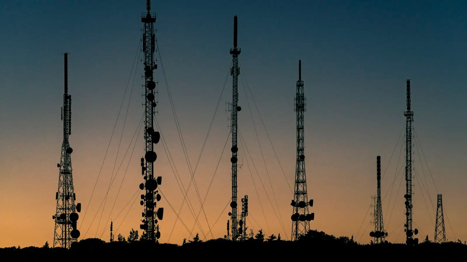Telecommunications tower with antenna arrays against a clear sky